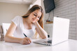 © Ivan - Young professional woman, trainee student noting in notebook, freelance copywriter freelancer making list planning tasks.
