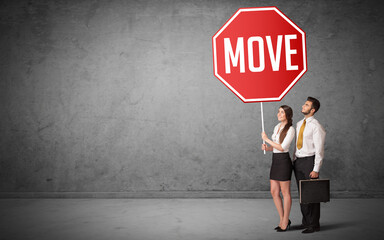 Young business person holding road sign with MOVE inscription, new rules concept