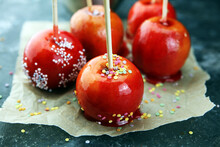 Sweet Red Glazed  Toffee Candy Apples On Sticks For Sale On Farmer Market Or Country Fair For Kids.