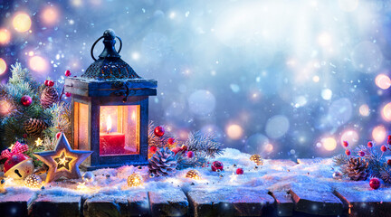 christmas lantern with fir branch and decoration on snowy table