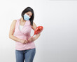 woman wearing mask in studio with red balloon heart