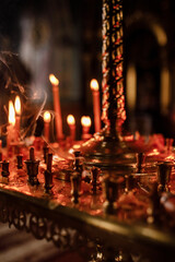 Wall Mural - Candles in the dark of a church. selective focus. noise is present