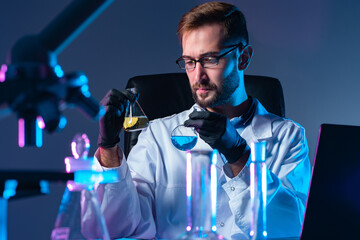 Poster - comparative analysis of chemical substances. male assistant holds in his hands the chemical flasks w