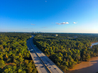 Wall Mural - a stunning aerial shot of vast miles of lush green trees, the freeway, the Chattahoochee river and blue sky at sunset  at the Chattahoochee River National Recreation Area in Sandy Springs Georgia