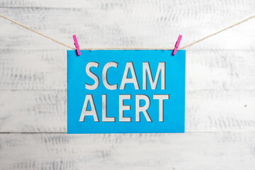Poster - Handwriting text Scam Alert. Conceptual photo unsolicited email that claims the prospect of a bargain Clothesline clothespin rectangle shaped paper reminder white wood desk