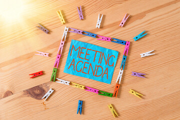 Fototapete - Conceptual hand writing showing Meeting Agenda. Concept meaning items that participants hope to accomplish at a meeting Colored crumpled papers wooden floor background clothespin