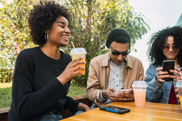 Wall Mural - Afro friends having fun together while drinking fruit juice.