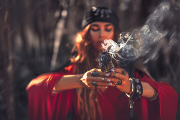 Wall Mural - close up of woman hands with shamanic fire outdoors