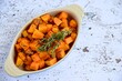 Baked pumpkin cubes with thyme on white background