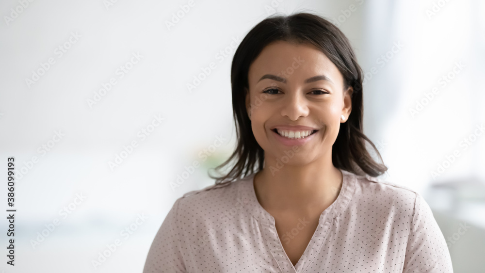 Narrow wide panoramic view headshot portrait of smiling African American young woman pose at home. Banner profile picture of happy biracial female renter or tenant look at camera. Copy space. - obrazy, fototapety, plakaty 