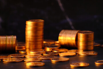 stack of golden coins on black background and advertising coins of finance and banking, increasing columns of gold coins on table