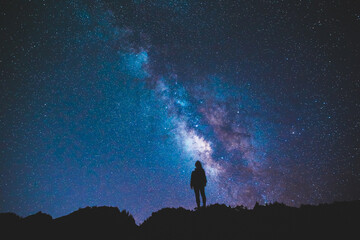 silhouette of girl / woman standing on the hill. stargazing at oahu island, hawaii. starry night sky