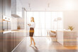 © ImageFlow - Woman in white and dark wooden kitchen