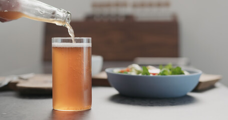 man pour soda drink from a bottle into highball glass on concrete countertop with copy space