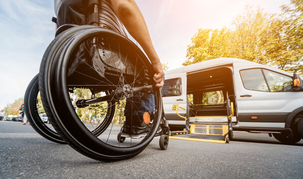 a man in a wheelchair moves to the lift of a specialized vehicle