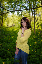 Beautiful Young Woman With Short Hair In Yellow Sweater Among Blossoming Spring Celandine Flowers.