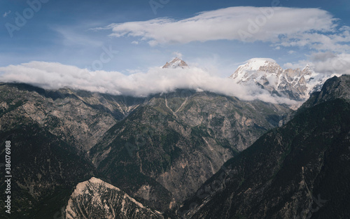 Fotomural Snow peaked Himalayas shrouded in clouds and mountain slopes