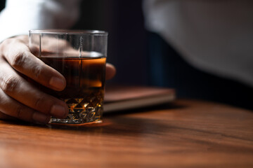 holding beverage drink in hand on table with dark moody lighting