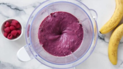 Wall Mural - Purple blueberry smoothie mixing in blender. Preparing healthy berry smoothie