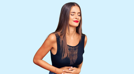 Wall Mural - Young hispanic woman wearing casual clothes with hand on stomach because indigestion, painful illness feeling unwell. ache concept.