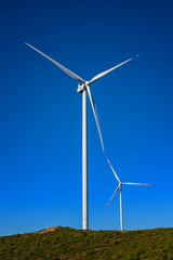 Wall Mural - wind turbines on a beautiful blue sky in a mountain wind farm in sardinia. renewable energy concept,