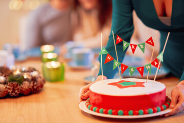 Wall Mural - Group of friends celebrating Christmas at home with fancy cake