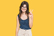 © Krakenimages.com - Young beautiful caucasian girl wearing casual clothes and glasses showing and pointing up with fingers number two while smiling confident and happy.