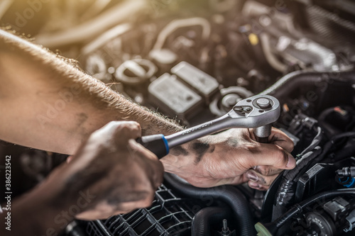 Obraz Dibond Auto mechanic working and repair on car engine in mechanics garage. Car service.