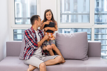 Canvas Print - a young father with his little daughter reads the Bible