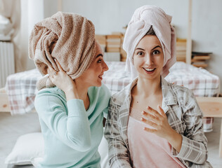 Two girls make homemade face and hair beauty masks. Cucumbers for the freshness of the skin around the eyes. Women take care of youthful skin