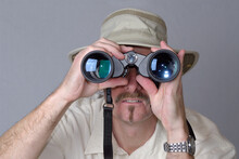 Man With Hat Looking Through Binoculars