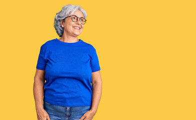 Wall Mural - Senior woman with gray hair wearing casual clothes and glasses looking away to side with smile on face, natural expression. laughing confident.