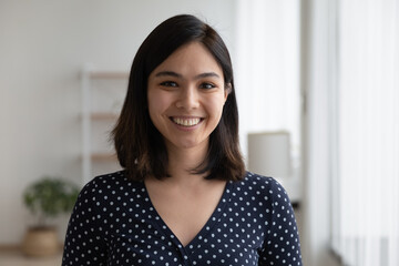 Wall Mural - Profile picture of smiling young Vietnamese woman show optimism leadership. Close up headshot portrait of happy millennial asian 20s female renter or tenant pose look at camera in own flat apartment.