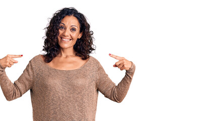 Wall Mural - Middle age beautiful woman wearing casual sweater looking confident with smile on face, pointing oneself with fingers proud and happy.