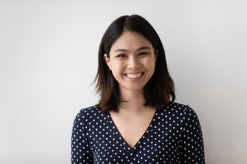 Wall Mural - Profile picture of smiling millennial asian girl isolated on grey wall background look at camera posing. Headshot portrait of happy young Vietnamese woman renter or tenant satisfied with service.