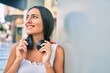 © Krakenimages.com - Young latin girl smiling happy using headphones leaning on the wall.