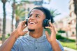 © Krakenimages.com - Young african american man listening to music using headphones at the city.