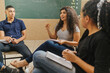 Leinwandbild Motiv Latin students in the classroom. students doing group study. curly hair female student talking