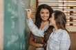 Latin students in the classroom. female student teaching each other about the task on the blackboard during class