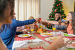 © Brastock Images - Summer Christmas dinner in Brazil. Real Brazilian family having fun at the Latin American Christmas party. happy family making a christmas toast