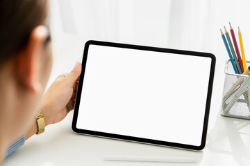 Closeup of woman hand holding digital tablet on the table and the screen is blank.