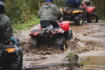 Wall Mural - Group of riders riding atv vehicle on off road track, process of driving ATV vehicle, all terrain quad bike vehicle, during offroad competition, crossing a puddle of mud