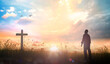 Easter Religious concept: Silhouette christian over cross meadow sunset background
