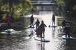 © tsuguliev - Group of sup surfers stand up paddle board, women stand up paddling together in the city river and canal