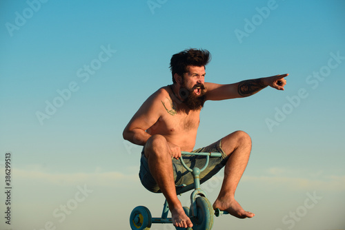Fotomural Crazy man riding a small bicycle. Funny man.