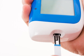 Closeup hands woman measuring glucose test level checking on a finger by glucometer she monitors and controls high blood sugar diabetes and glycemic health care concept isolated on white background