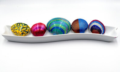 festive and colorful painted shells arranged horizontally against a white background