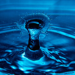 Water drop falling down. Abstract blue background