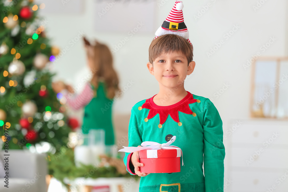 Cute little elf with gift at home on Christmas eve