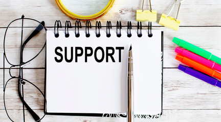 Poster - SUPPORT written in a notebook on white background with office tools